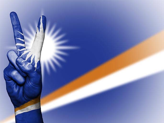 picture of the Marshall Islands flag with peach hand symbol to accomodate blog post about Marshall Island cryptocurrency
